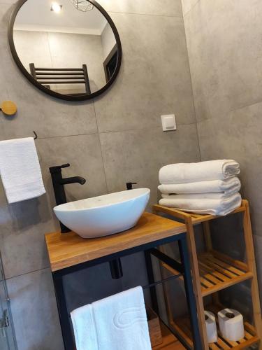 een badkamer met een witte wastafel en een spiegel bij Apartament typu studio Morski Sen-centrum in Mielno