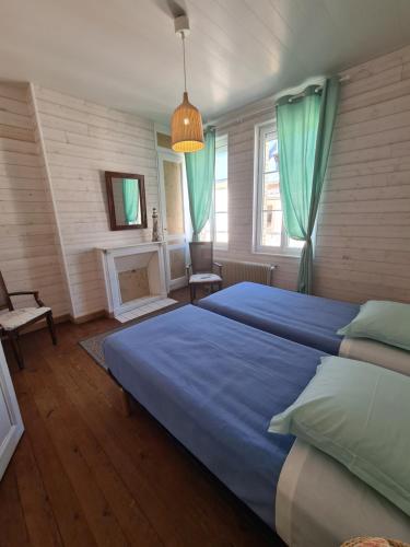 - une chambre avec un grand lit bleu et une cheminée dans l'établissement Maison de pêcheur typique proche plage, à Fécamp