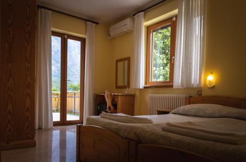 a bedroom with two beds and a large window at Agriturismo la campagnola in Gordona