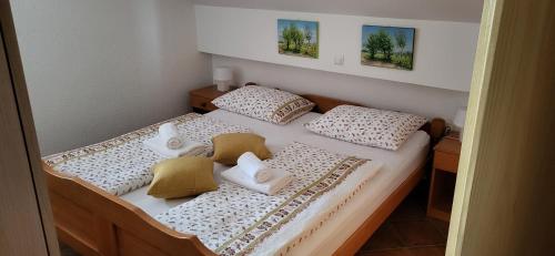 a bedroom with a bed with two pillows at Vila Lisina in Seliste Dreznicko