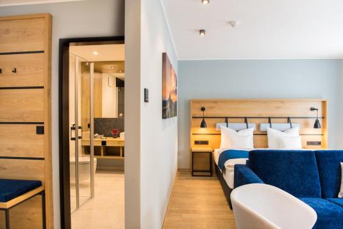 a bedroom with a bed and a blue couch at Aktivhotel Inselsberg in Tabarz