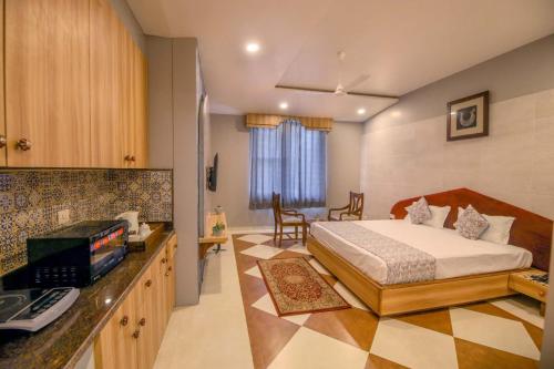 1 dormitorio con 1 cama y escritorio con teléfono en Gems Suites-A Boutique Stay en Jaipur