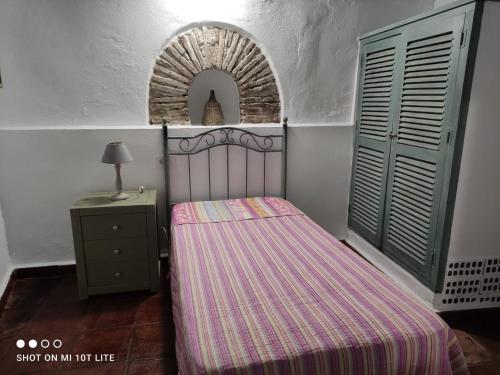 - une petite chambre avec un lit et une table de nuit dans l'établissement Casa Ana, à Jimena de la Frontera