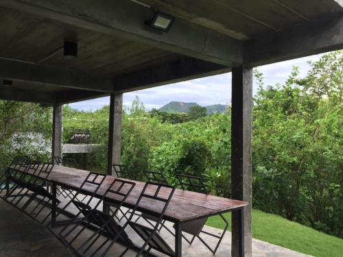 a wooden table and chairs on a porch with a view at ชลลดา ริเวอร์ โฮมสเตย์ แก่งกระจาน in Ban Wang Malako