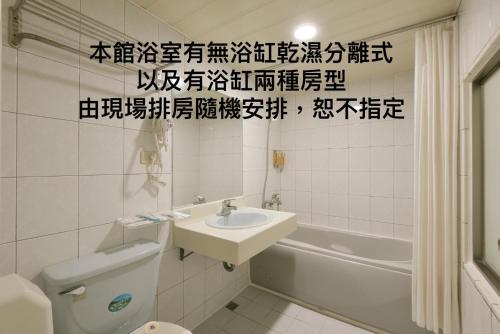 a bathroom with a sink and a toilet and a tub at The Rivero Hotel in Kaohsiung