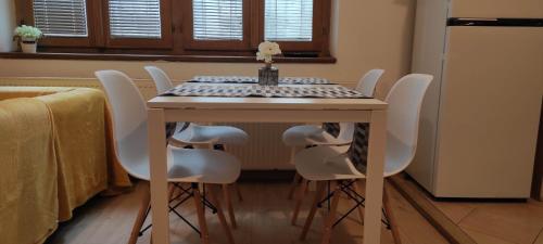 una mesa de comedor con sillas blancas alrededor en Apartment Kate - Old Town en Bratislava