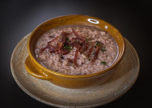 a bowl of oatmeal with bacon on a plate at Agriturismo la campagnola in Gordona