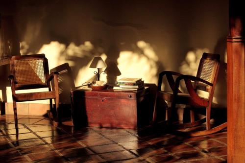 a room with two chairs and a desk with a lamp at Hotel Patio del Malinche in Granada