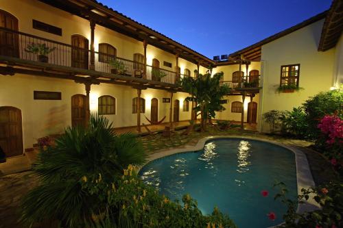 einen Innenhof mit einem Pool vor einem Gebäude in der Unterkunft Hotel Patio del Malinche in Granada