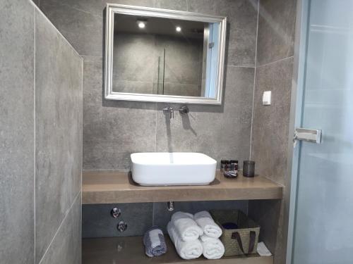 a bathroom with a sink and a mirror and towels at Memories of Cotton in Agios Nikolaos