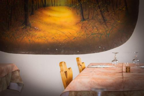 a table in a room with a painting on the wall at Agriturismo la campagnola in Gordona