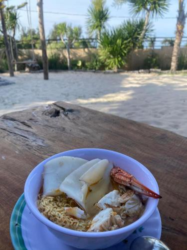 a bowl of food sitting on a table at Hành Ngò Homestay - Hòn Đỏ Ninh Thuận in Thôn Dư Khánh