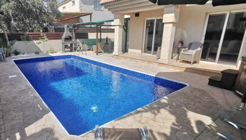 a swimming pool in front of a house at GREAT VILLA MARIA in Paralimni