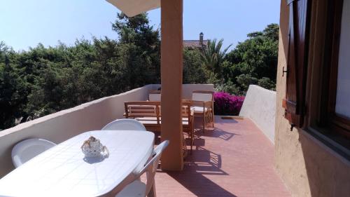 een witte tafel en stoelen op een balkon bij I Ginepri Holiday Home in Marina di Sorso