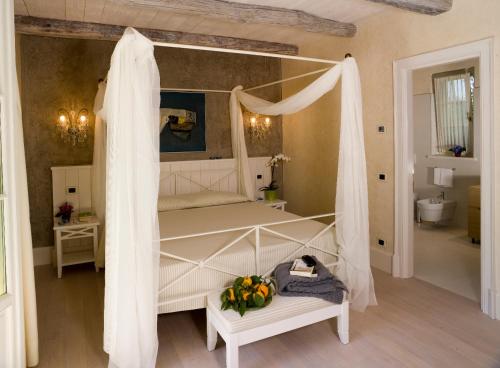 1 dormitorio con 1 cama blanca con dosel en Park Hotel Villa Belvedere en Cannobio