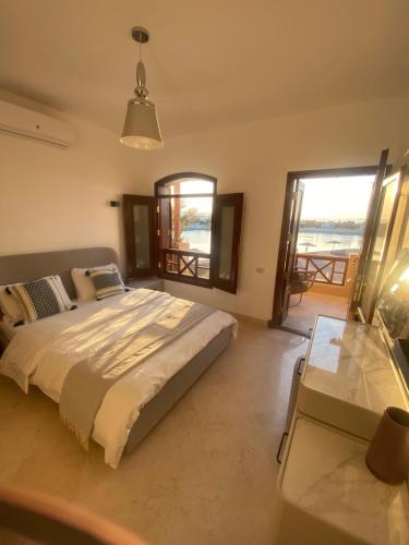 a bedroom with a bed and two tables and windows at Sabina 2br penthouse in Hurghada