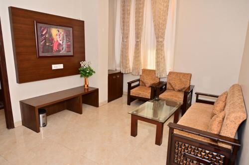een woonkamer met een bank en 2 stoelen bij Hotel Radiance Courtyard in Varanasi