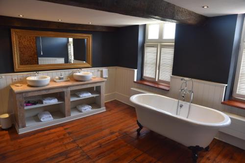 a large bathroom with two sinks and a tub at In De Swaene in Kortessem
