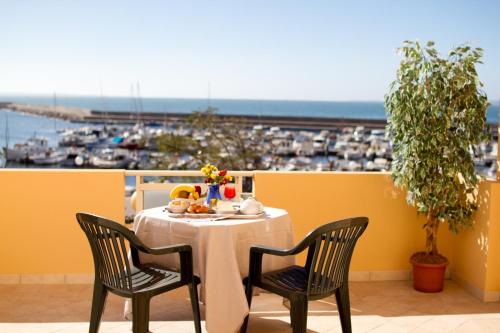 einen Tisch auf einem Balkon mit Meerblick in der Unterkunft Hotel Don Pedro in Portoscuso