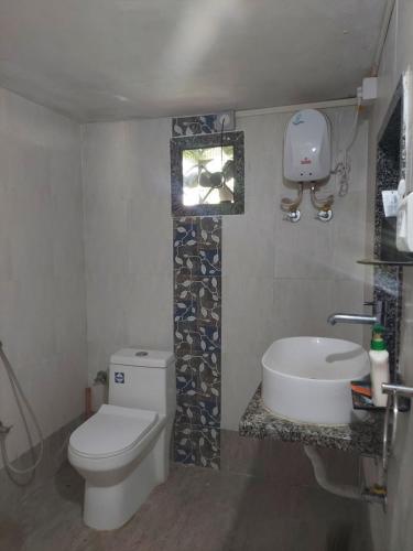 y baño con aseo, bañera y lavamanos. en JAWAI WILD LODGE, en Bijāpur