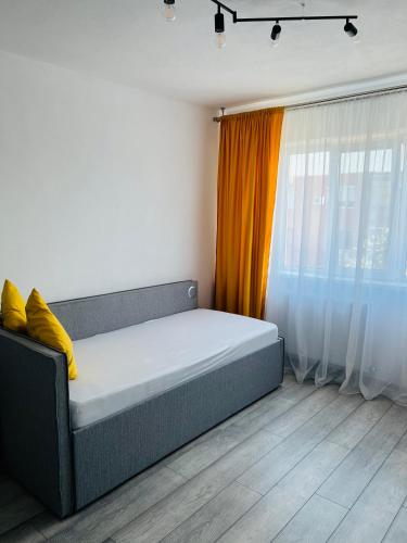 łóżko w pokoju z pomarańczową zasłoną w obiekcie Miha modern and central apartament w mieście Arad