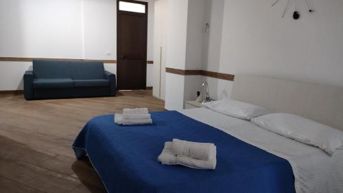 una camera da letto con un letto blu e asciugamani di Sogno d'estate a Mazara del Vallo