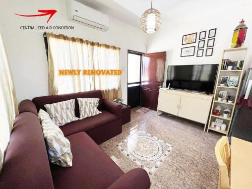 a living room with a couch and a tv at Villa Mercedita Subdivision - Centralized Aircon at Gene Vacation Homes in Davao City