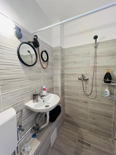 łazienka z umywalką i prysznicem w obiekcie Miha modern and central apartament w mieście Arad