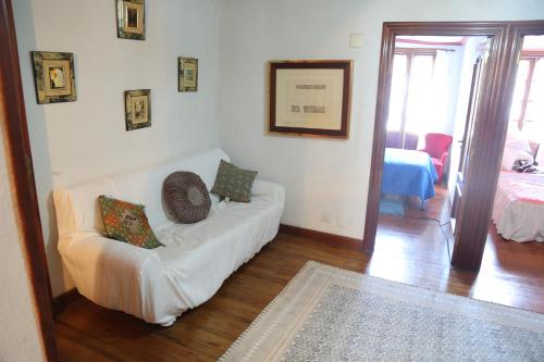 een woonkamer met een witte bank met kussens erop bij Habitaciones Dobles en Casa in Villanueva