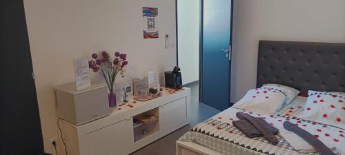 - une chambre avec un lit et un vase de fleurs dans l'établissement CHAMBRE COSY Adults only, à Agde