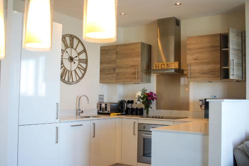 a kitchen with white cabinets and a clock on the wall at Kent Breath-taking VIEW 2BD/2BA with Free Parking in Kent