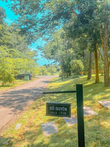 a sign in the grass next to a road at Villa Đỗ Quyên F5B in Ngọc Quang