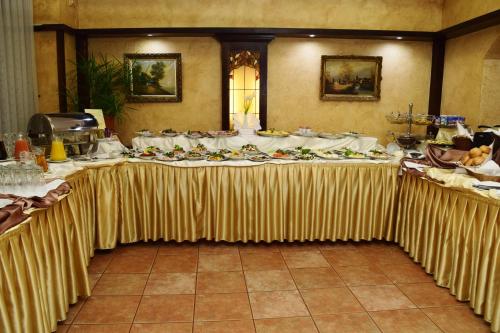 a long table with a table cloth with food on it at Hotel Retman in Toruń