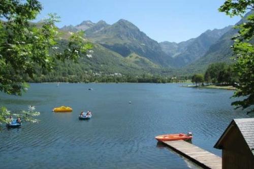 a group of boats on a lake with mountains at Appartement T4 8 couchages spacieux et cosy au pied des pistes in Génos
