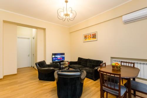 una sala de estar con un sofá y una mesa en New!-Downtown Apartment ll, en Tiflis