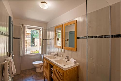 bagno con lavandino, servizi igienici e specchio di Gîte Du Pont - Piana a Piana