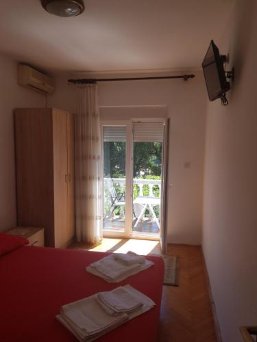 Ένα ή περισσότερα κρεβάτια σε δωμάτιο στο Sobe i apartmani Marović