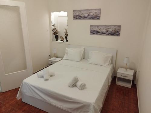 1 dormitorio con 1 cama blanca y 2 toallas en Zeus Apartment en Athens
