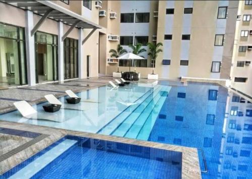 a swimming pool in a hotel with a building at Cozy235 studio at The Persimmon in Cebu City