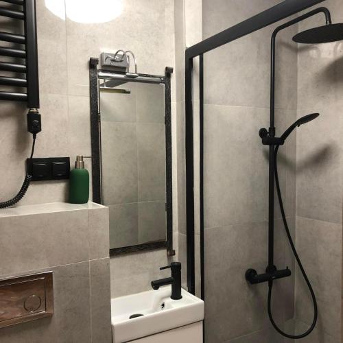 a bathroom with a shower and a sink at Hostel BAZA 15 in Wrocław