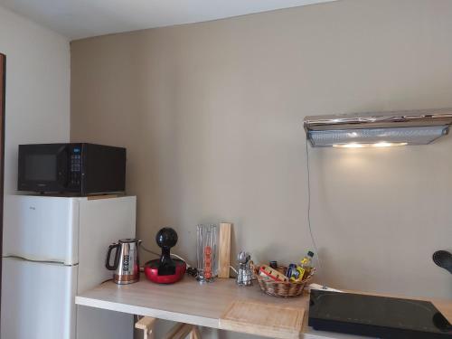 une cuisine avec un réfrigérateur blanc et un plan de travail dans l'établissement La Guest House BYLAVILLA25 calme et détente, à Noaillan