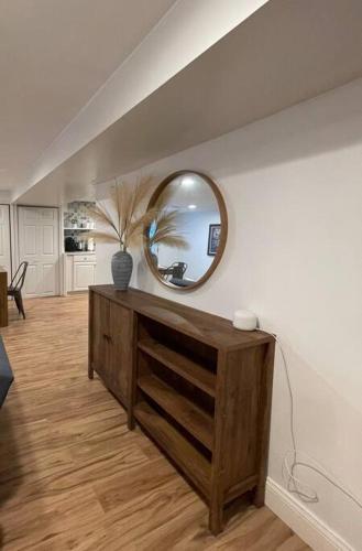 a living room with a mirror and a wooden dresser at Upscale, Brand New, Full Kitchen, 2-Bedroom Apt in Falls Church
