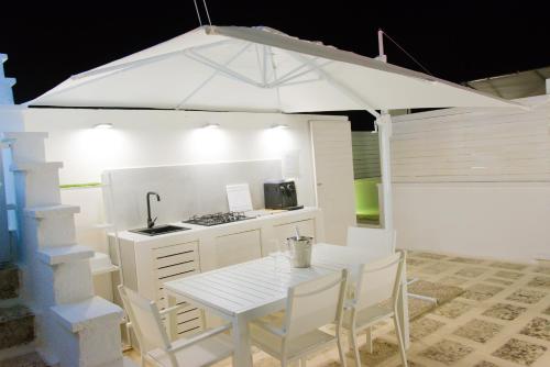 - une cuisine avec une table et un parasol blanc dans l'établissement ArcoSalento, à Galatina