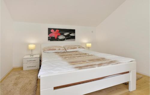 a white bed in a white bedroom with two lamps at Lovely Home In Tuhelj With Sauna in Tuhelj