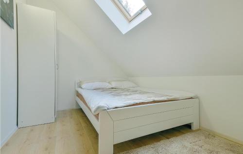 a bed in a white room with a window at Lovely Home In Tuhelj With Sauna in Tuhelj