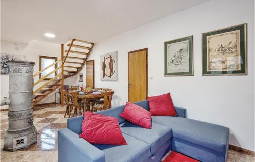a living room with a blue couch and red pillows at Lovely Home In Tuhelj With Sauna in Tuhelj