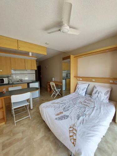 une chambre avec un grand lit et une cuisine dans l'établissement Le Cosy des Minimes, à La Rochelle