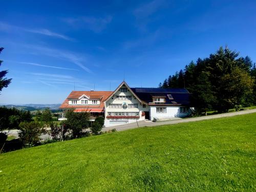 una casa grande en una colina con un campo verde en Hirschen Wald, en Wald