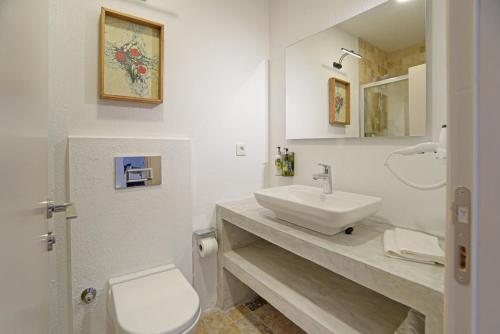 La salle de bains blanche est pourvue d'un lavabo et de toilettes. dans l'établissement POM Alaçatı Boutique Otel, à Çeşme