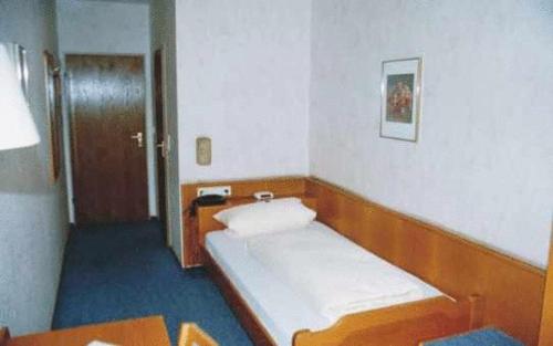 Cette petite chambre comprend un lit et une table. dans l'établissement Hotel Ludwigstal, à Schriesheim